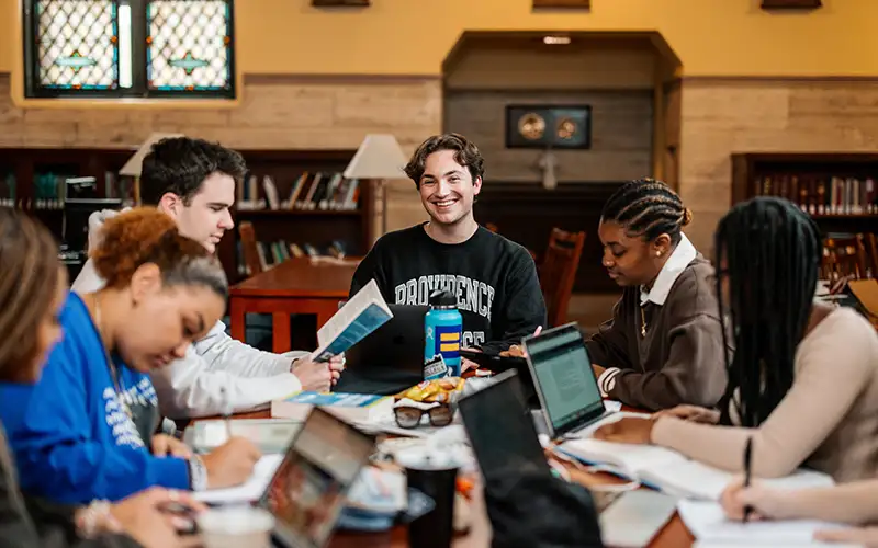 students studying around a table at the library 