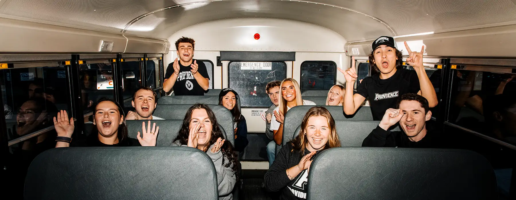 Friar Fanatics in a bus cheering